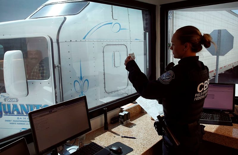  A Customs and Border Patrol agent reviews the credentials of a Mexican truck driver at the border. Some fleets use Mexican nations to haul goods out of Mexico into the U.S. inside the border zone. Those fleets must ensure those drivers have proper insurance coverage. 