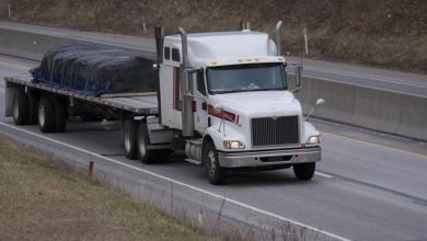 A tractor hauls a fltabed trailer and its load. t(Photo credit: Shutterstock)