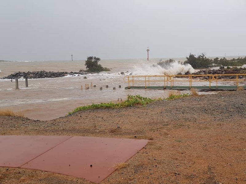    In this EXCLUSIVE photo  , we can see what a spring tide-storm surge tide looks like at Port Hedland. This is a marine launch jetty (the dark greenish platform with a yellow guard rail). Readers can observe the wooden stumps just above the water to its immediate left. And, to the far left, there are a couple of logs sticking out of the water. That is the marine jetty. The water level is supposed   to be below   that jetty by a couple of feet. Mariners normally jump up from the side of the launch onto the jetty. Photo: supplied to FreightWaves by a source. 