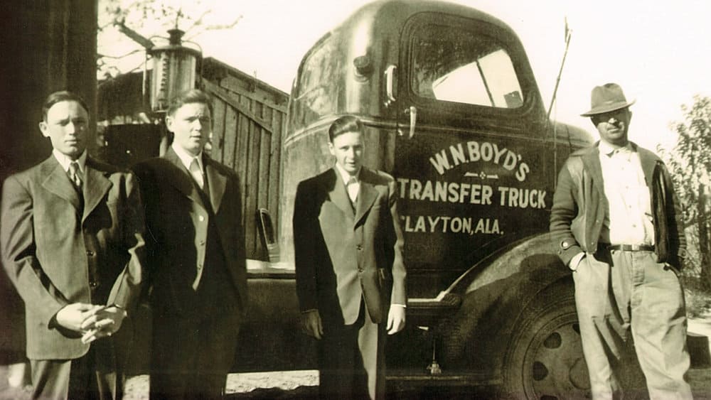  image courtesy of Flickr/Trucking PR   Cecil Boyd, at left, and his brothers Hilly and Dempsey, stand next to a tractor their father, William Boyd, right, operated. Following World War II, the Boyd brothers drove trucks for 10 years before starting their own company in 1956 - Boyd Brothers trucking. 