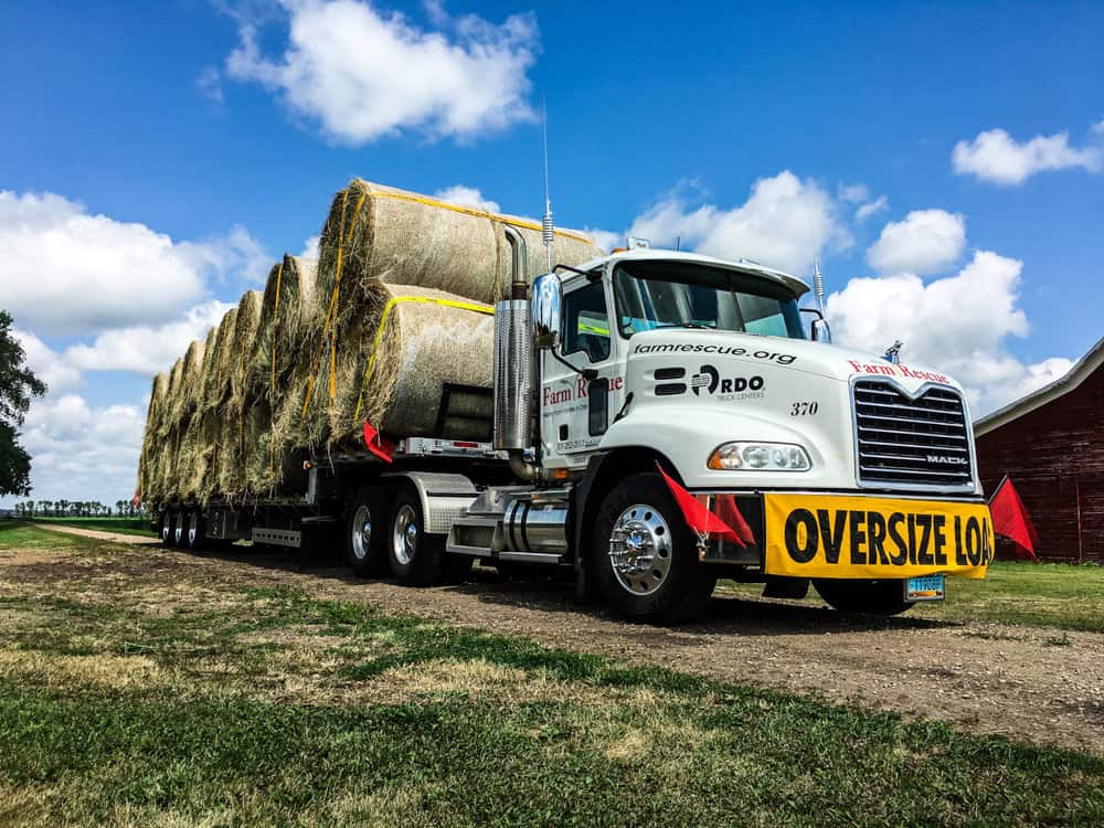  Hundreds of truck drivers across the Midwest volunteered their time to deliver hay bails to farmers affected by flooding in the MIdwest. ( Photo: Farm Rescue ) 