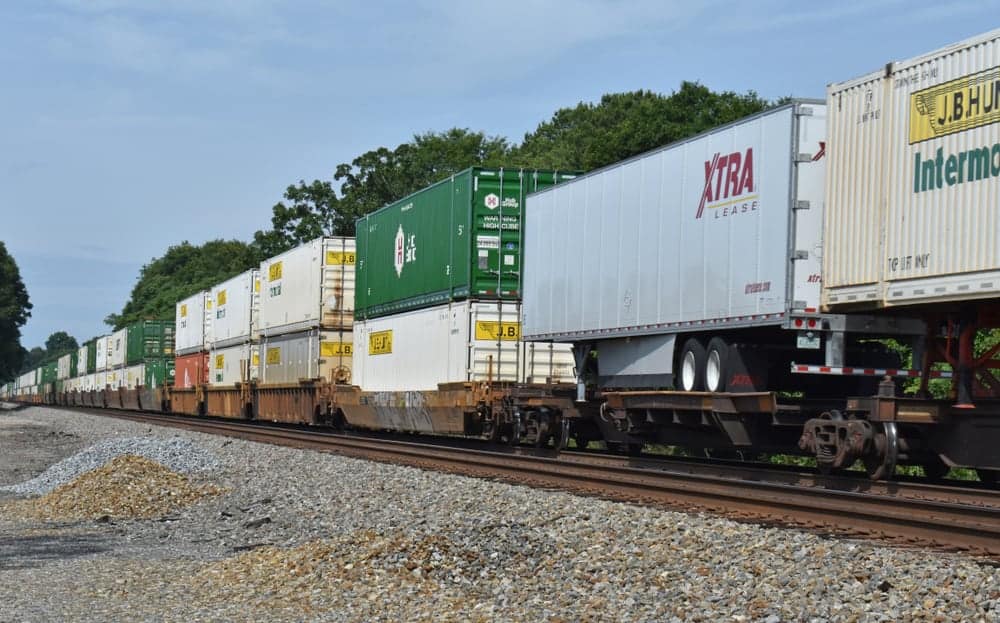 Intermodal railcars, in assorted colors, are stacked on rail cars.