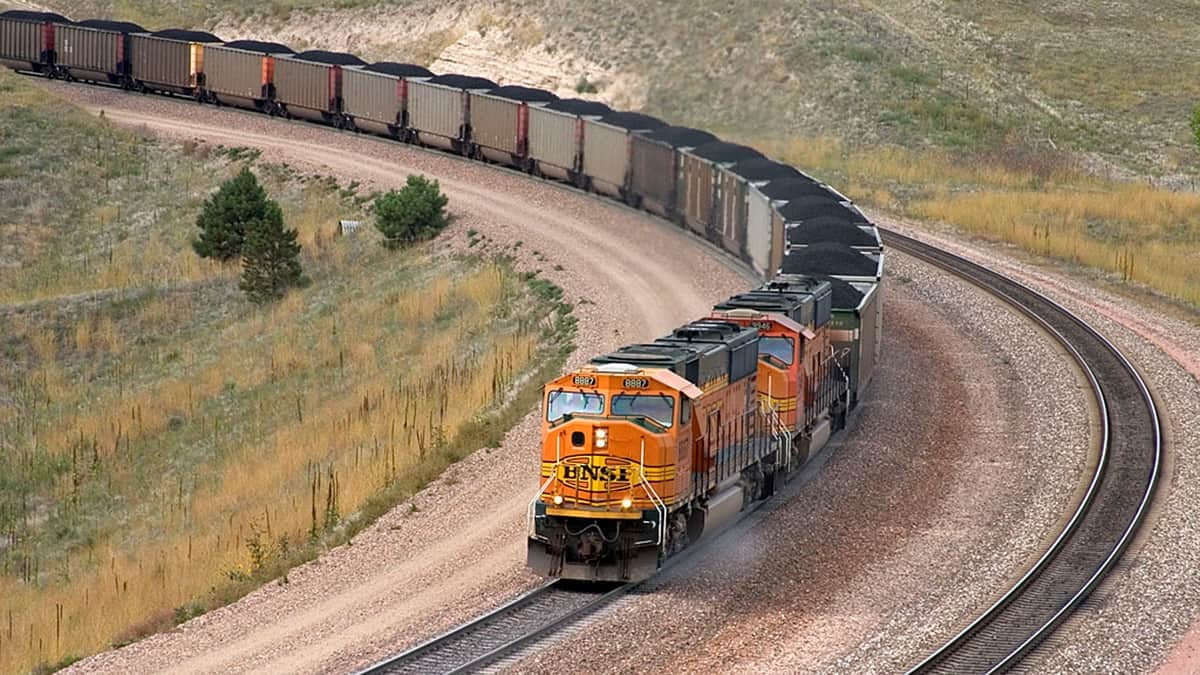 An orange BNSF train hauls coal