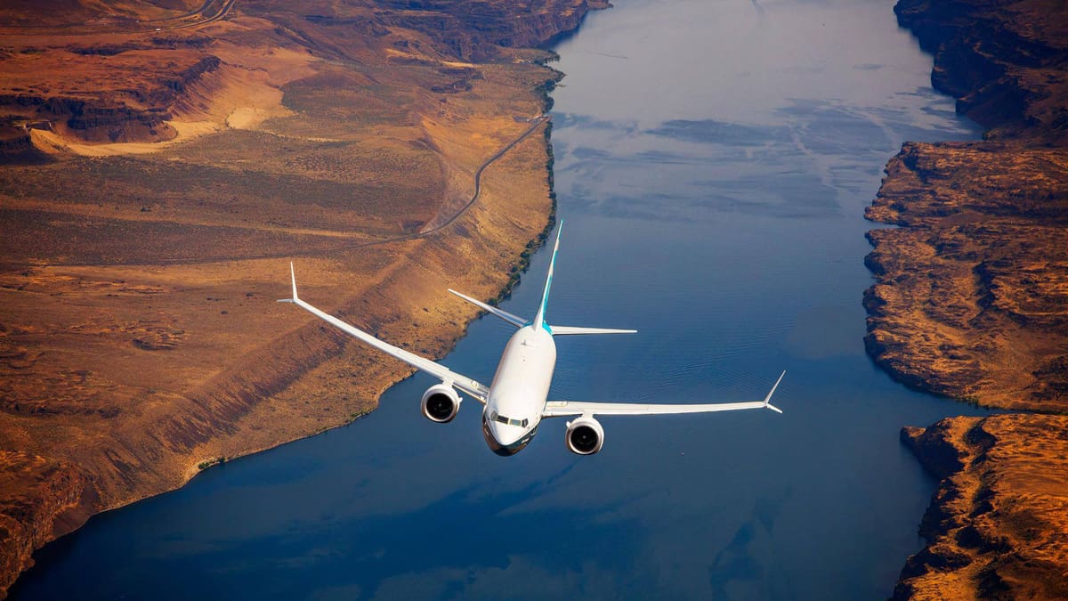 A plane flies over a river