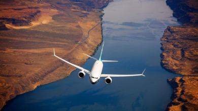 A plane flies over a river