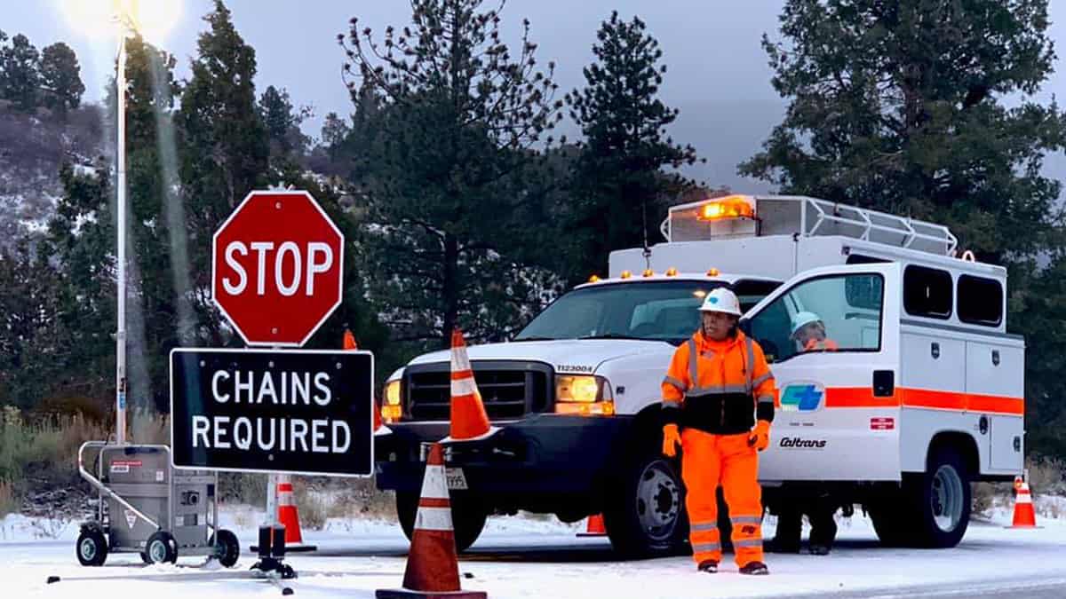 Road crew in southern California mountains posting "Road Closed" sign.