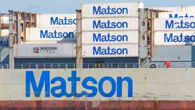 Pictures: ocean shipping containers stacked on a ship and all are bearing the Matson logo