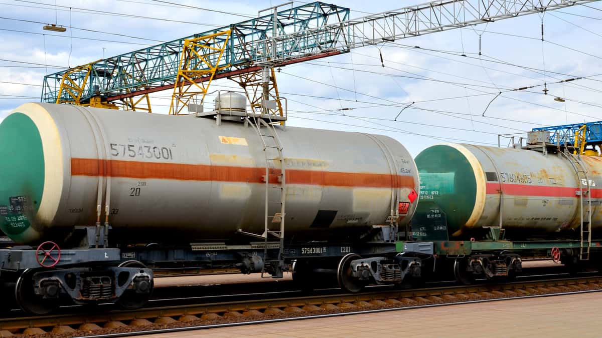 Two tank cars sit in a railroad yard.