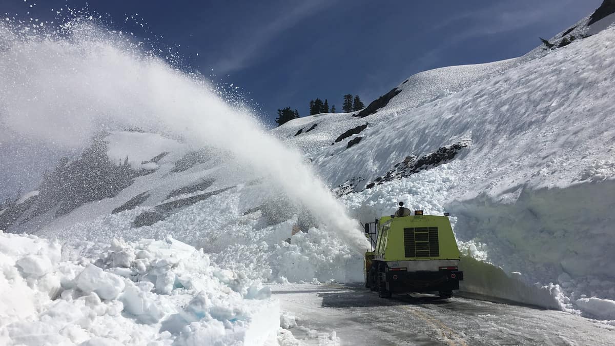 Truck plowing heaps of snow off a highway in Washington state.