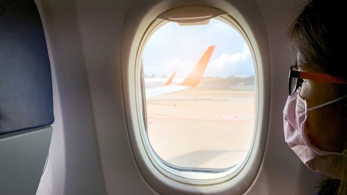 A woman on flight wears a germ mask.