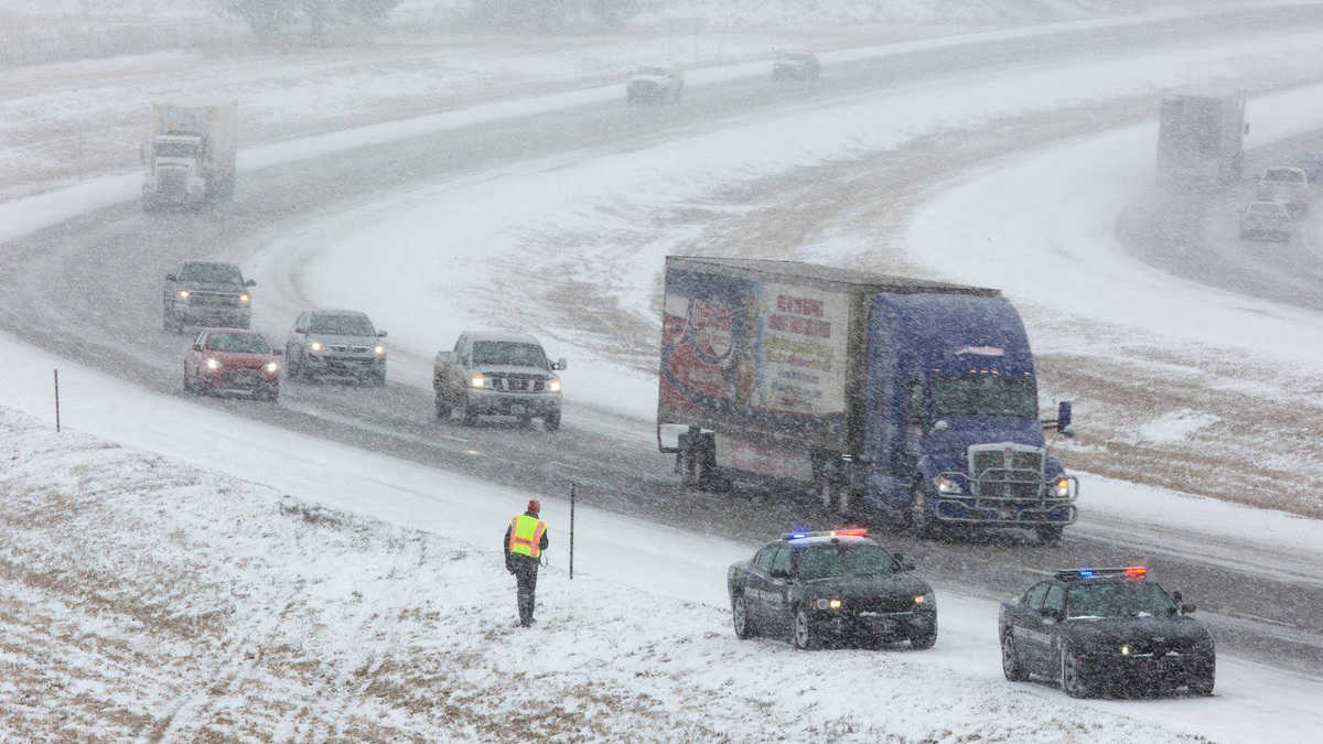 Trucks and other vehicles on a snowy Nebraska road.