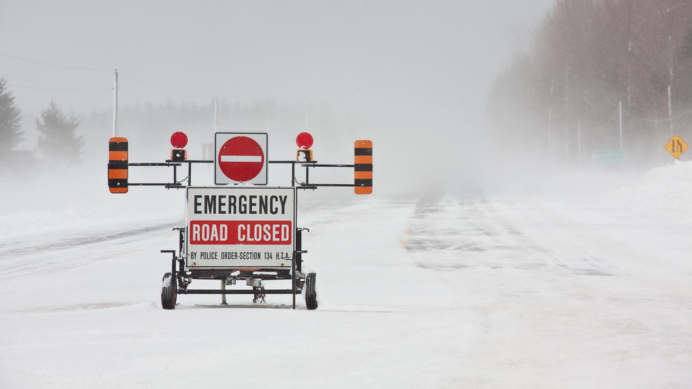 Road closed sign posted in blizzard area.