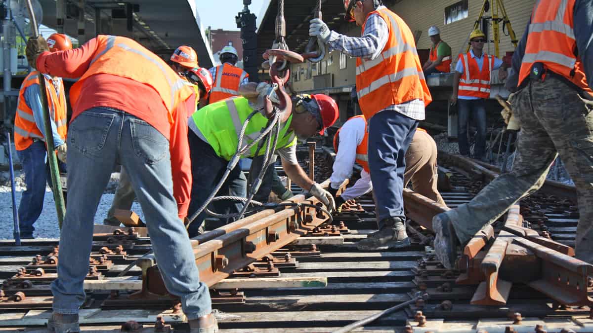 A photograph of railroad employees working on a railroad track.