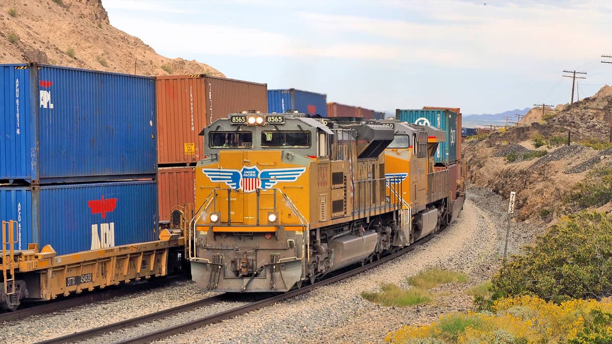 A photograph of a locomotive and intermodal containers.