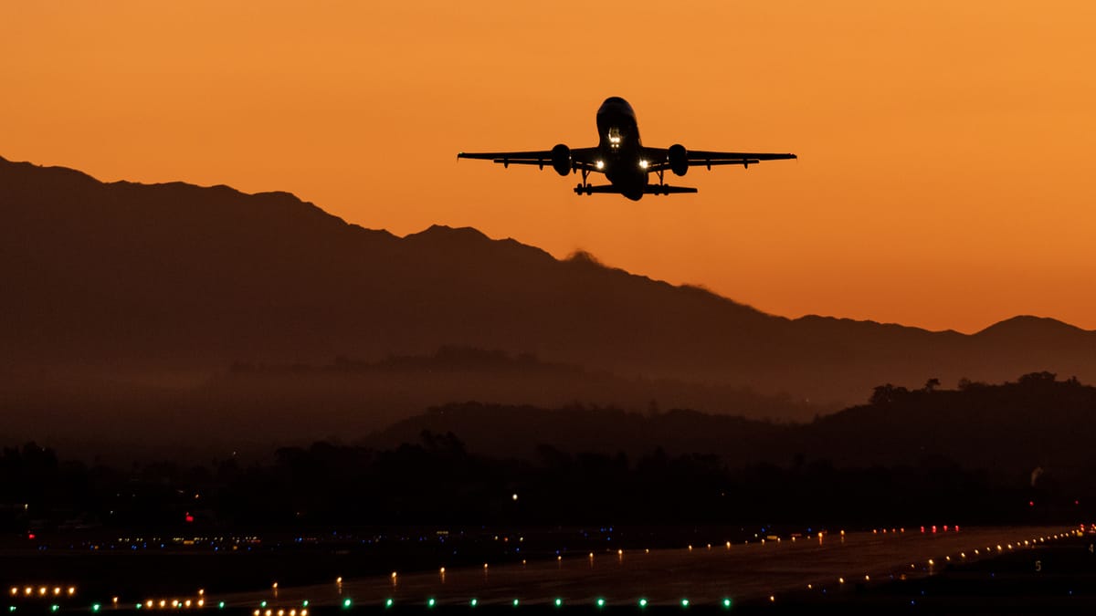 airliner taking off at sunset