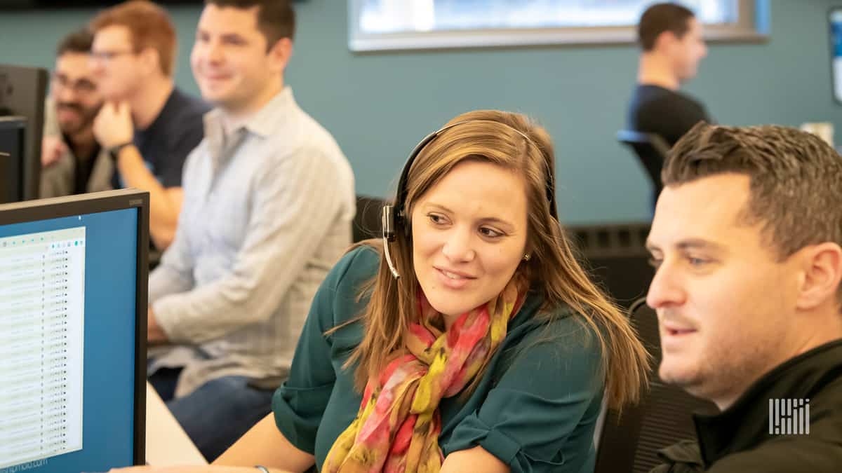 Members of the Molo Solutions team at their desks with monitors.