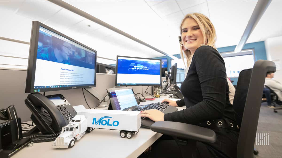 Young woman with headset at her Molo Solutions work station.