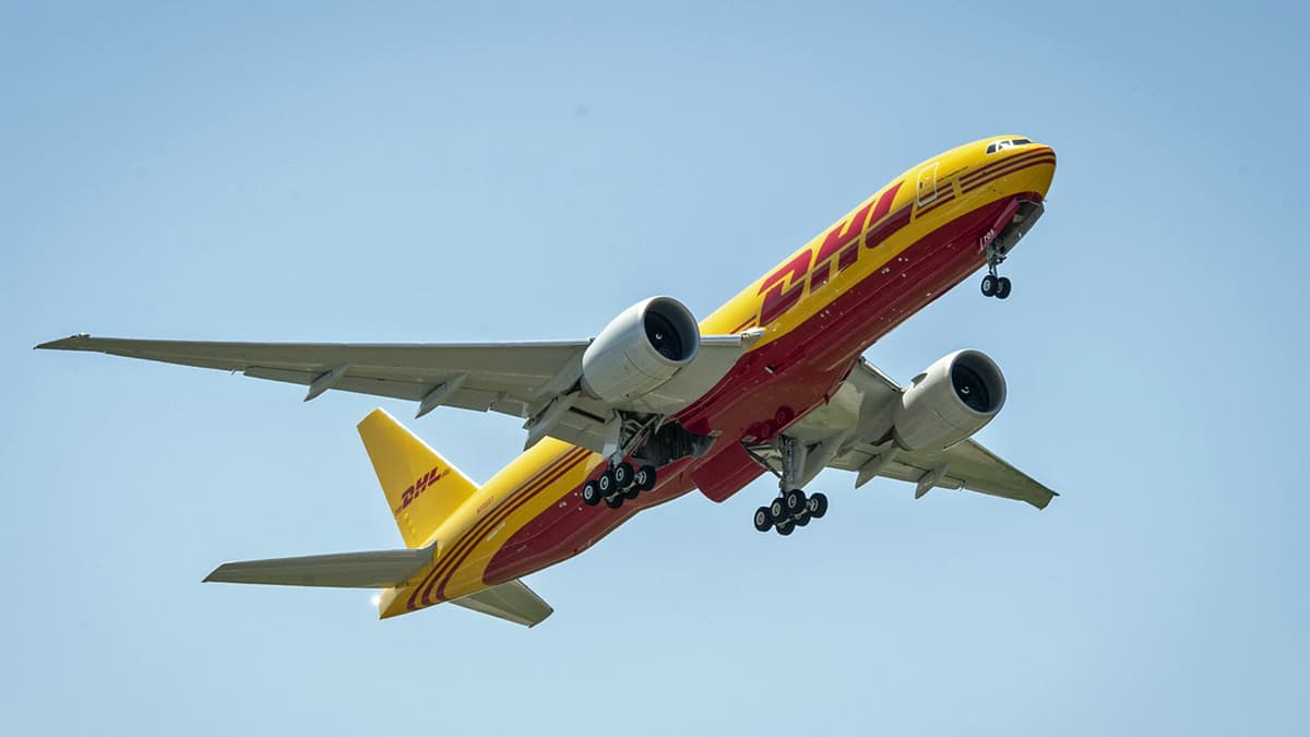 Mustard yellow DHL plane flying overhead.