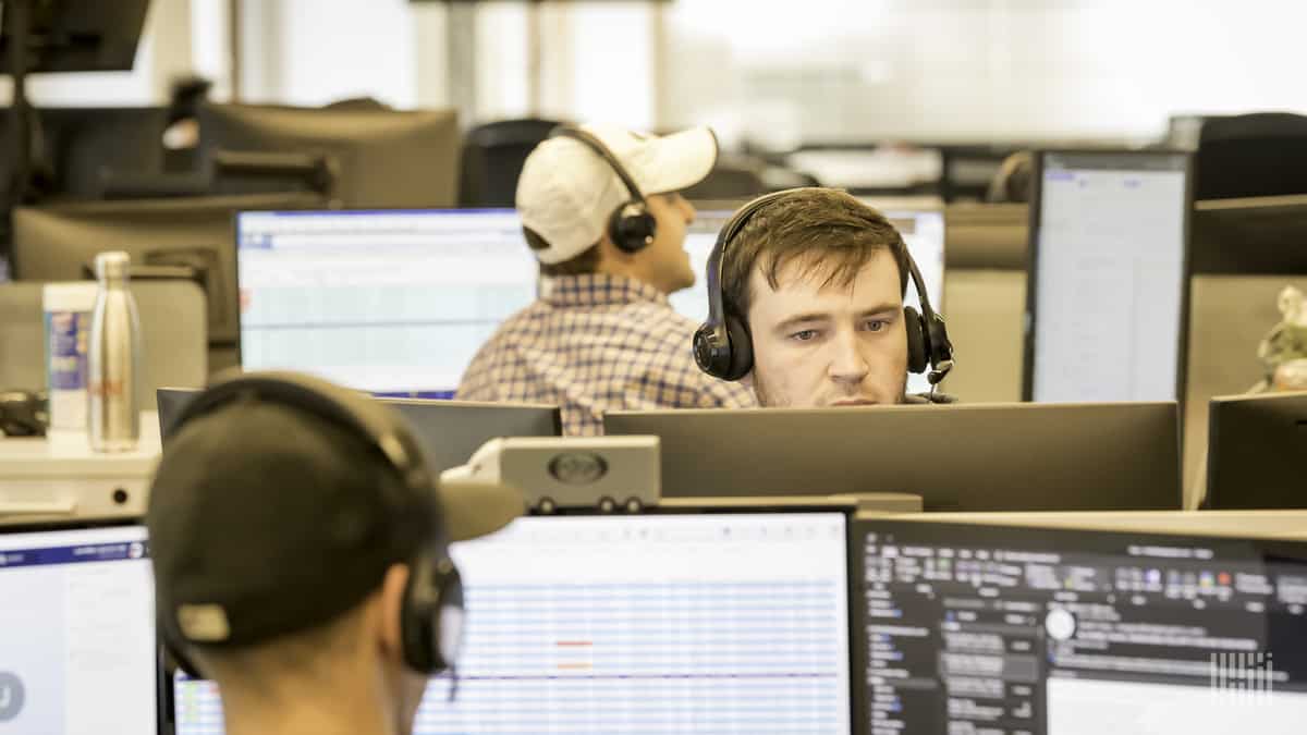 Man wearing headphones stares at computer screen