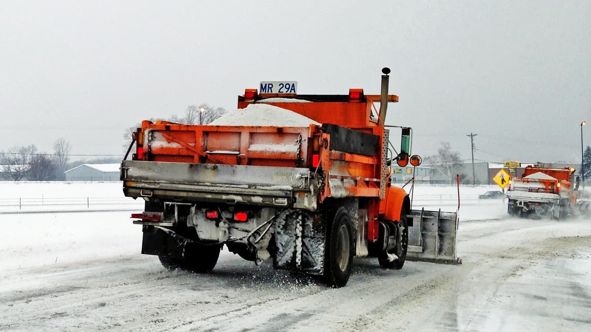 Plows clearing snowy Illinois highway.