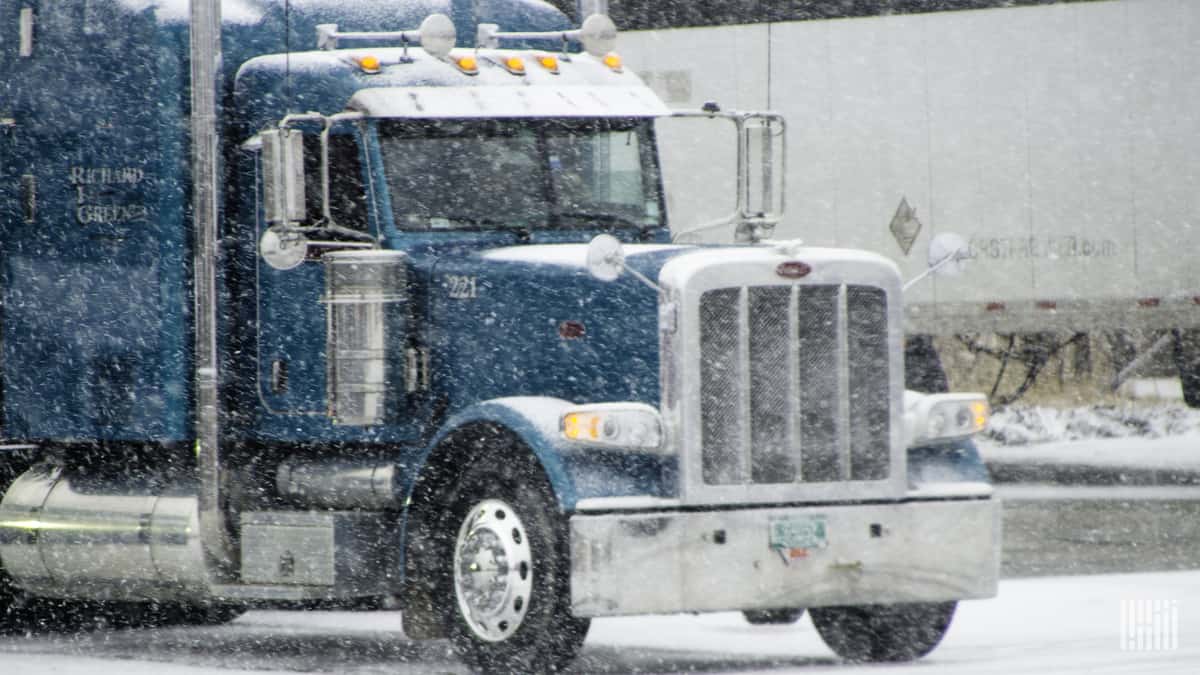 Tractor trailer on a snowy road.