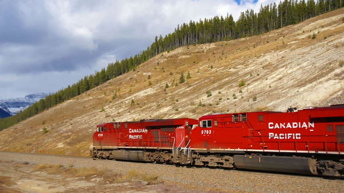 A photograph of a train by a hillside.