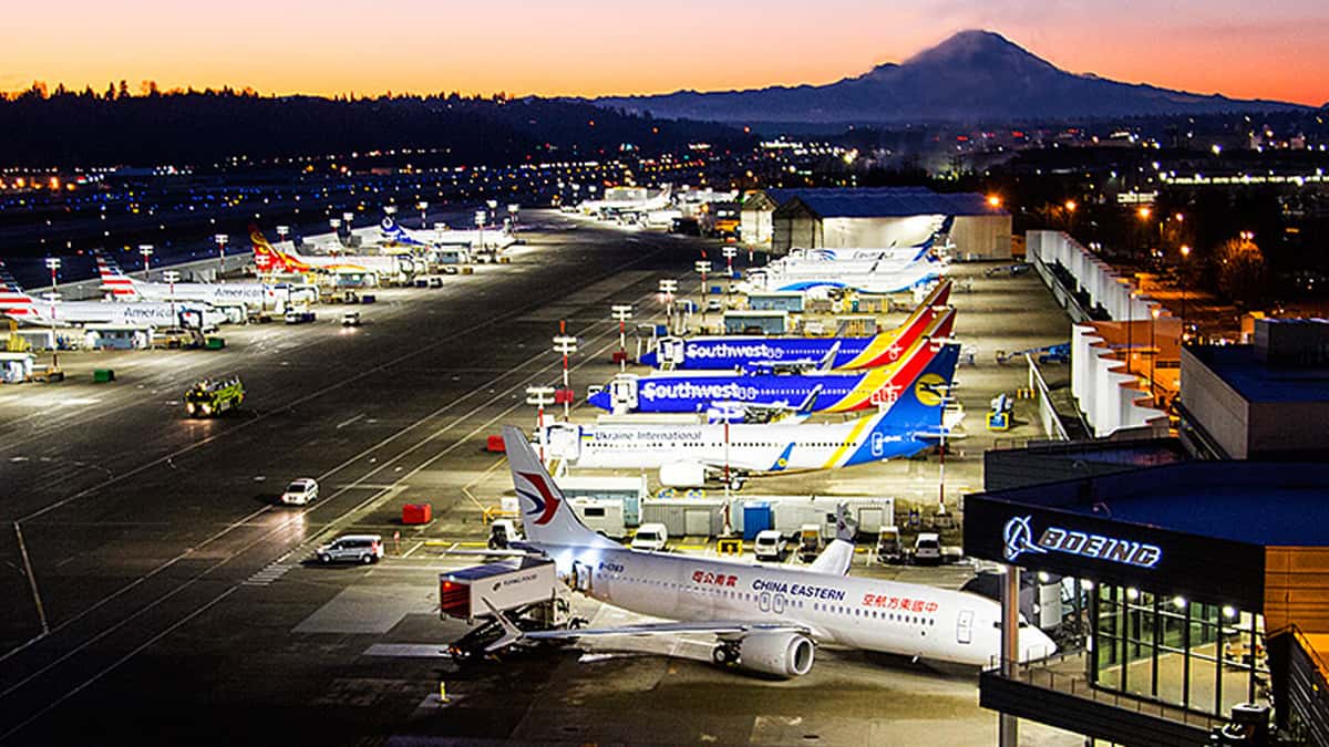 Sunset over Boeing plant with planes parked outside.