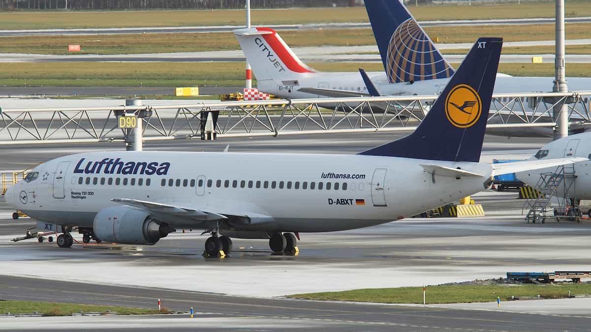 Lufthansa plane on taxiway at airport.
