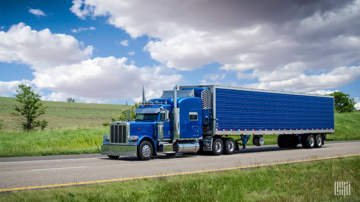 older blue tractor-trailer on highway