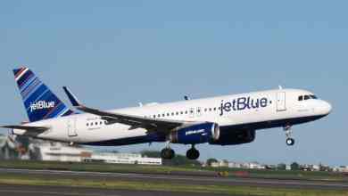 A blue and white JetBlue plane takes off.