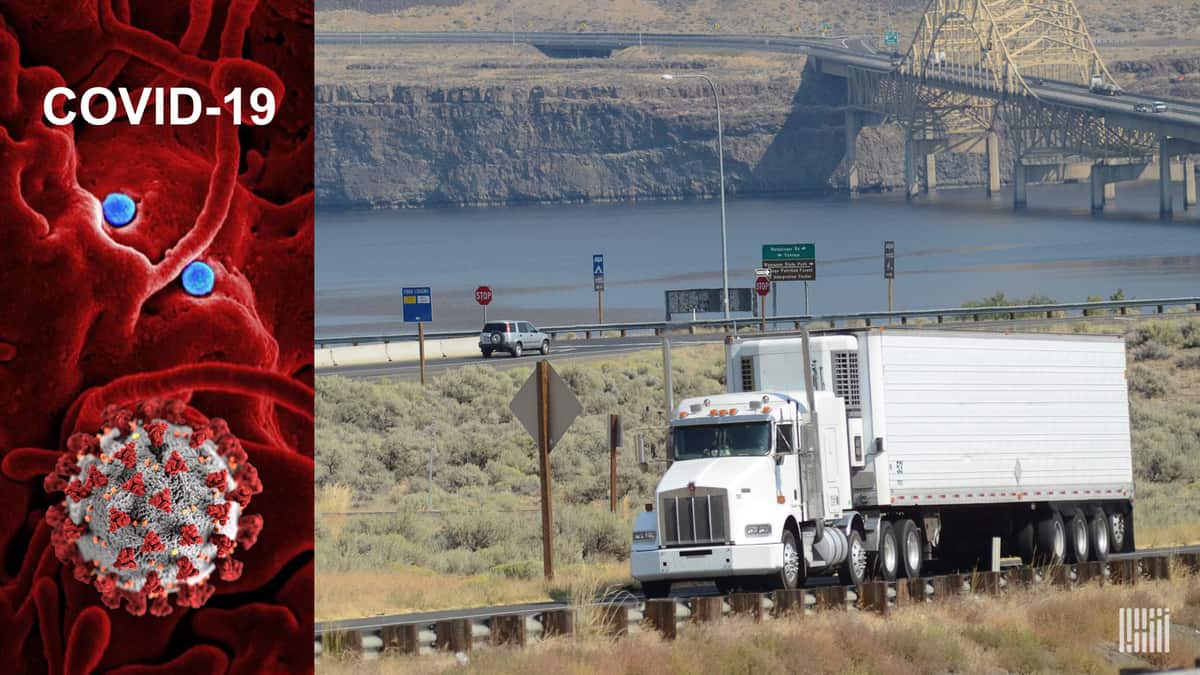 Truck moving along roadway with a COV(D-19 image.