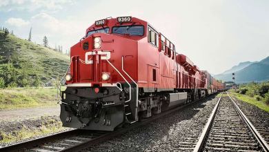 A photograph of a locomotive hauling railcars through a valley.