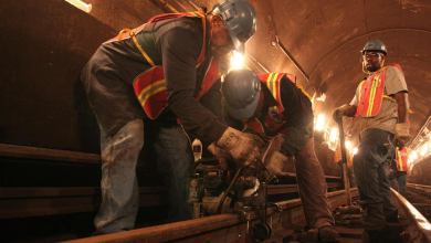 A photograph of workers fixing railroad track.