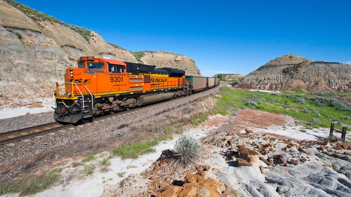 Two BNSF locomotives pull a freight train through the American West.