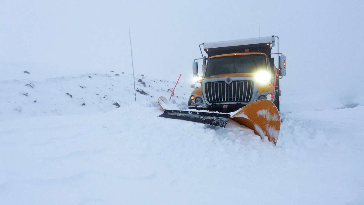 Plow clearing snowy Montana highway.