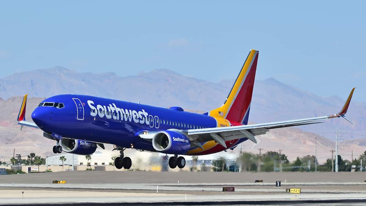 A bright blue and orange Southwest plane landing.