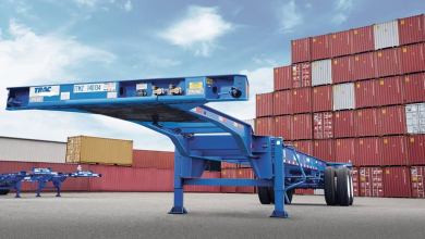 A photograph of a chassis. There are intermodal containers in the background.