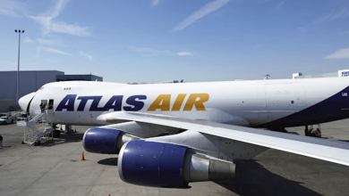 White jumbo jet sits on ramp at airport.