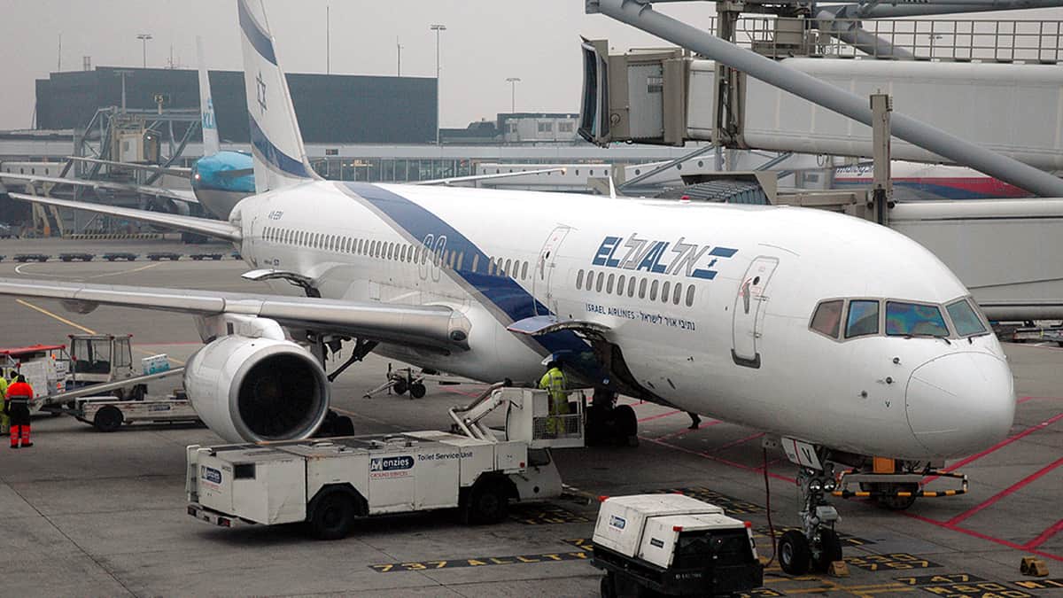 A white El Al plane at the airport gate.