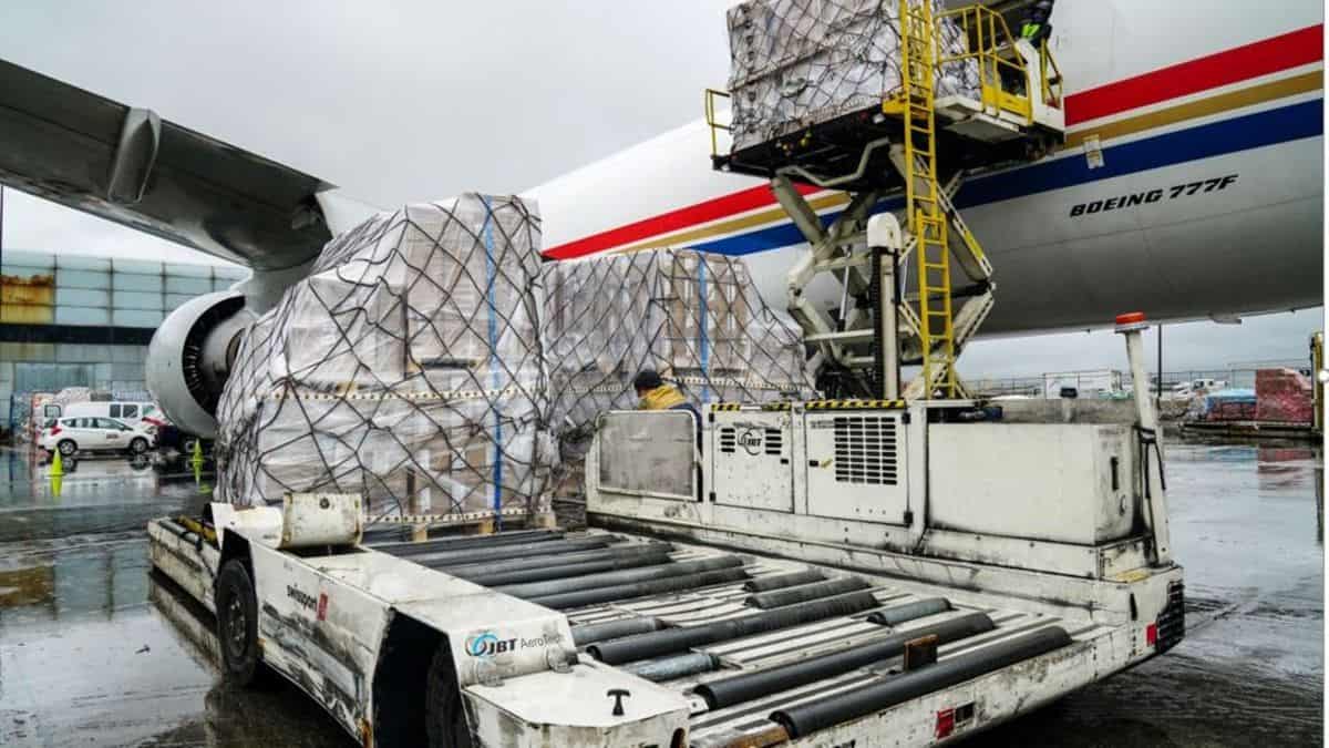 Pallets of cargo are unloaded from a big plane.