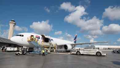 Cargo being unloaded from a large white cargo jet.