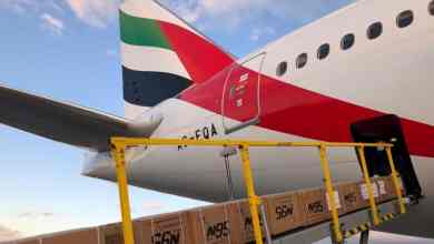 Cargo ets loaded via conveyor belt onto rear of a plane.