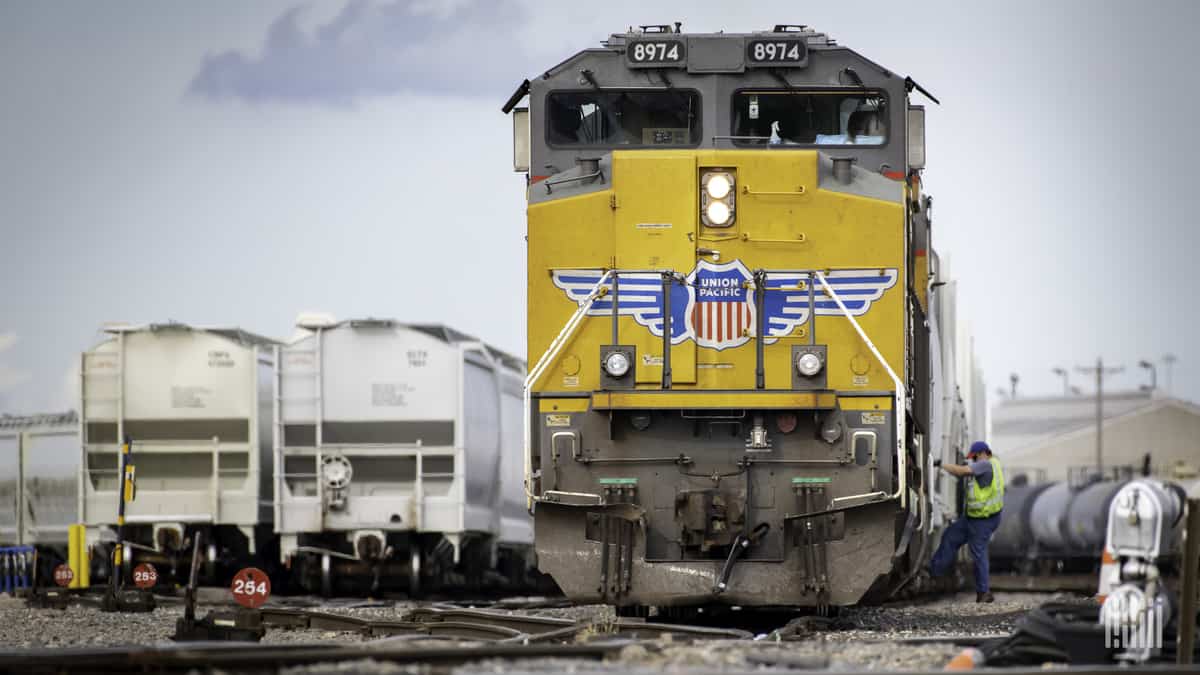 A photograph of a man boarding a freight train.