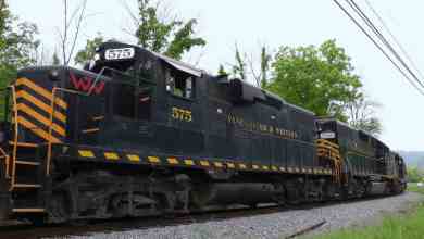 A photograph of a train locomotive. There are trees behind the train.