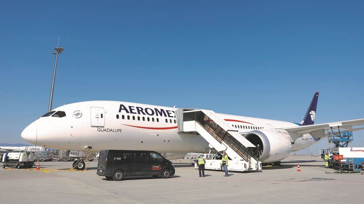 A white passenger jet with stairs leading up to front door.