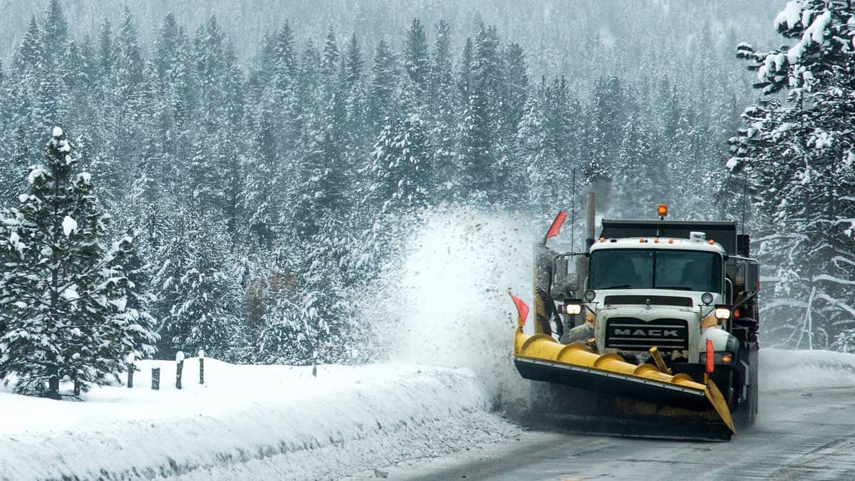 Plow clearing snowy Idaho highway.