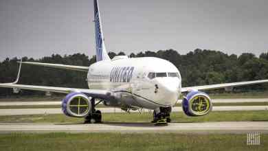 A white United Airlines plane in storage on tarmac.