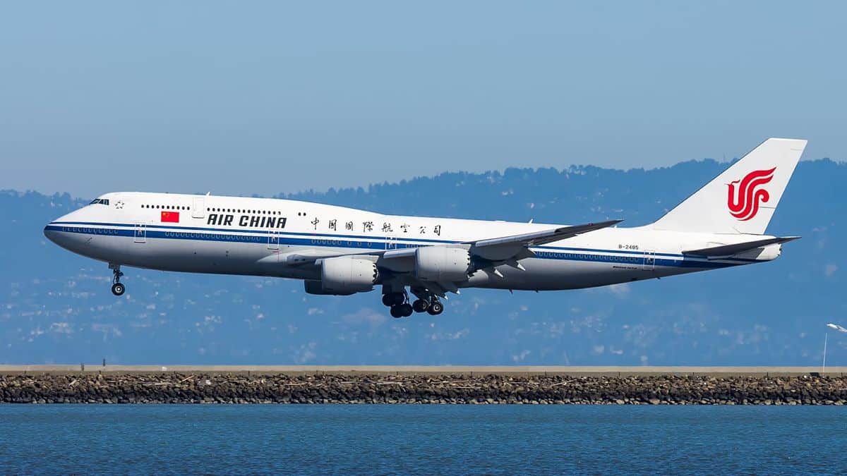 Big white jumbo jet comes in for landing over water at San Francisco Airport