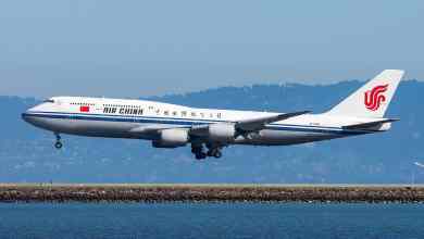 Big white jumbo jet comes in for landing over water at San Francisco Airport