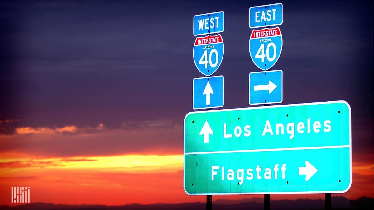 Interstate highway directional signs at sunset.
(Photo: Jim Allen/FreightWaves)